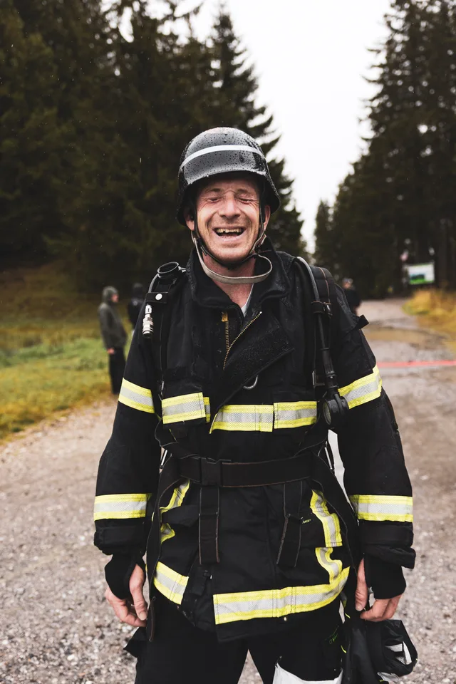 Lachender Teilnehmer mit schwarzem Helm nach dem Zieleinlauf.