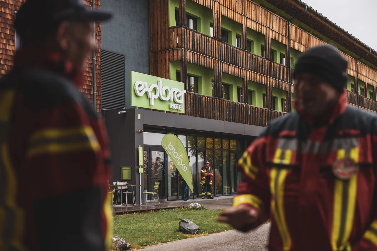 Feuerwehrleute stehen vor dem Explorer Hotel in Nesselwang.