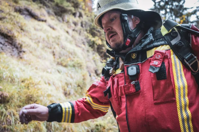 Nahansicht eines Teilnehmers in roter Einsatzkleidung auf der Waldtreppe.