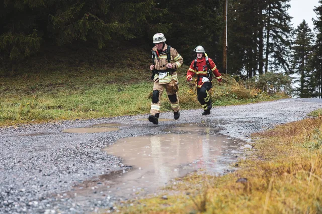 Zwei Teilnehmer in beiger und roter Einsatzkleidung erreichen die Zielmarkierung.