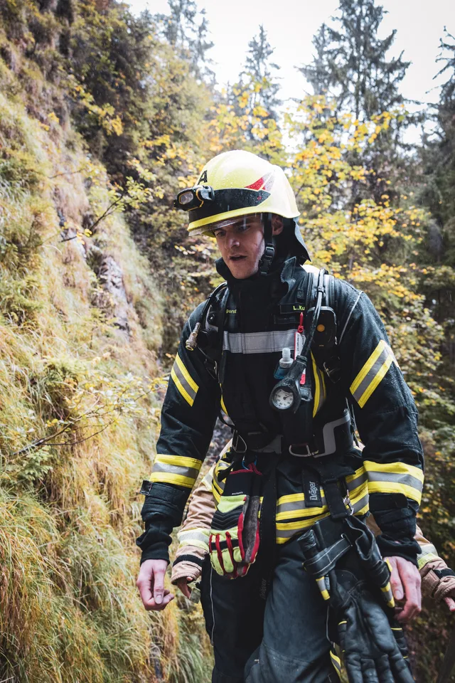 Teilnehmer mit gelbem Helm und dunkler Einsatzkleidung auf der Treppe.