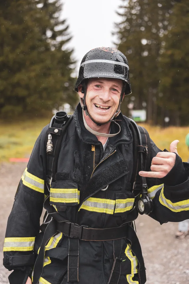 Lachender Teilnehmer mit schwarzem Helm nach dem Zieleinlauf.