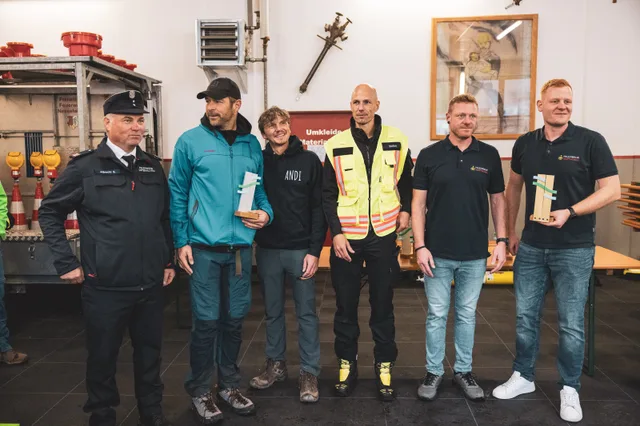 Gruppe mit Pokalen bei der Siegerehrung im Feuerwehrhaus.