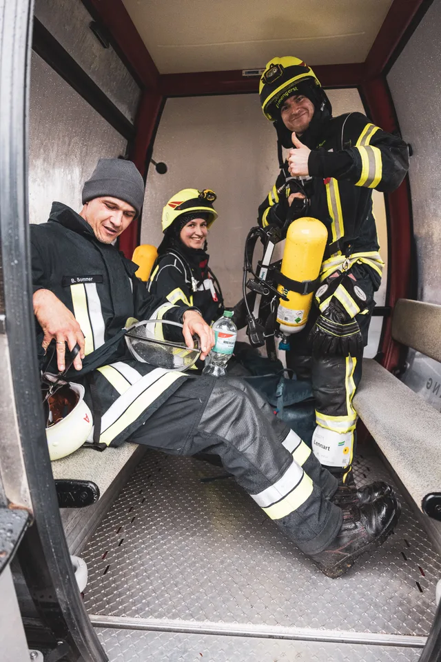 Teilnehmer in Einsatzkleidung sitzen in der Gondel der Alpspitzbahn.