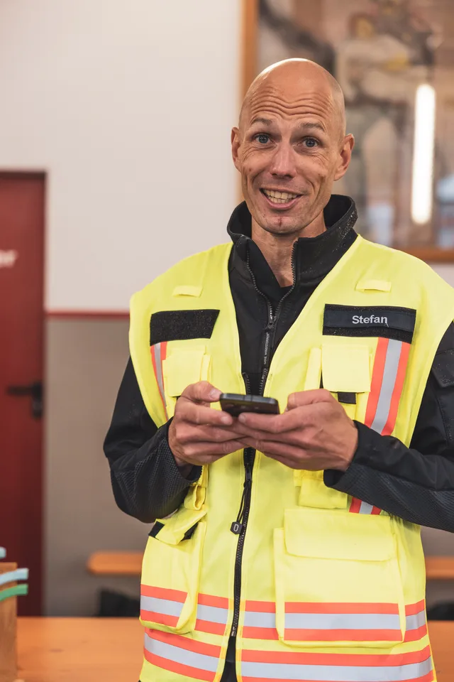 Organisator in Warnweste spricht im Feuerwehrhaus.