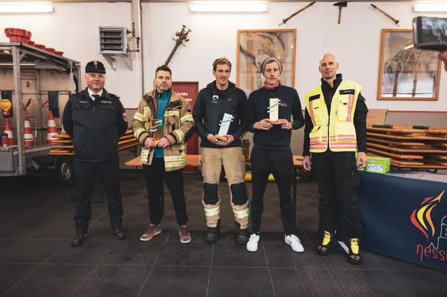 Teilnehmer mit Pokalen beim Gruppenbild im Feuerwehrhaus.