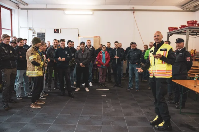 Organisator in Warnweste spricht vor den versammelten Teilnehmern.