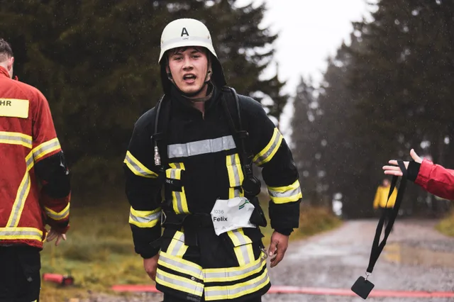 Teilnehmer mit weißem Helm und schwarzer Einsatzkleidung nach dem Zieleinlauf.