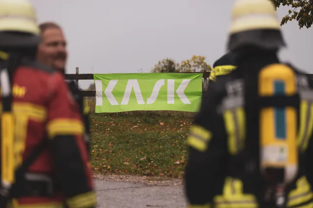 Veranstaltungsbanner hinter unscharfen Teilnehmern.