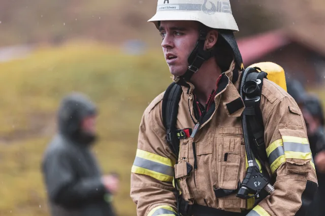Teilnehmer in beiger Einsatzkleidung und weißem Helm nach dem Zieleinlauf.