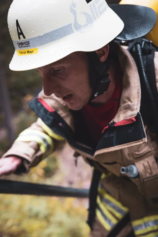 Teilnehmer mit weißem Helm neben dem Geländer der Metalltreppe.