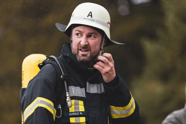Teilnehmer mit weißem Helm und Bart im Gespräch nach dem Zieleinlauf.