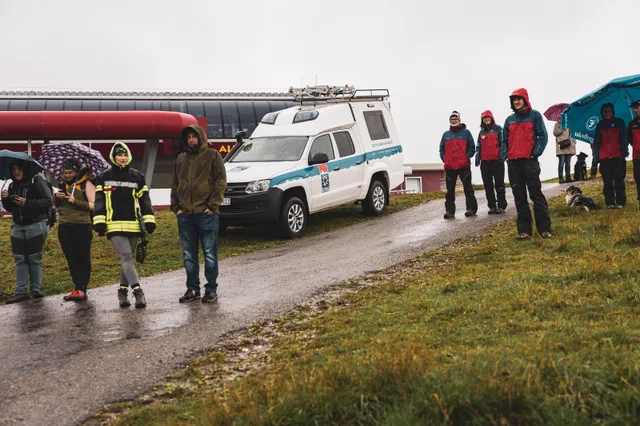 Helfer und Rettungsfahrzeug am Rand der Bergstraße.