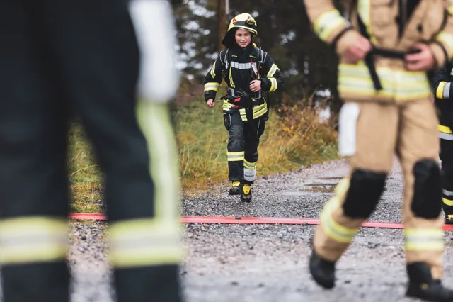 Teilnehmer in dunkler Einsatzkleidung läuft durch den Zielbereich.