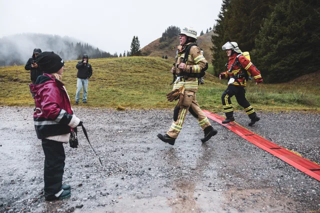 Zwei Teilnehmer in beiger und roter Einsatzkleidung erreichen die Zielmarkierung.