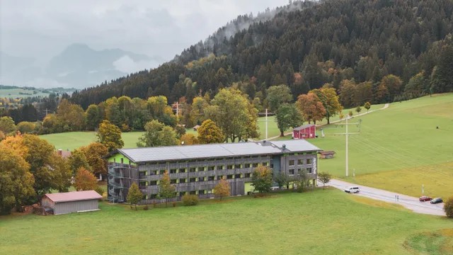 Luftaufnahme des Explorer Hotels vor Wiesen und Herbstwald.