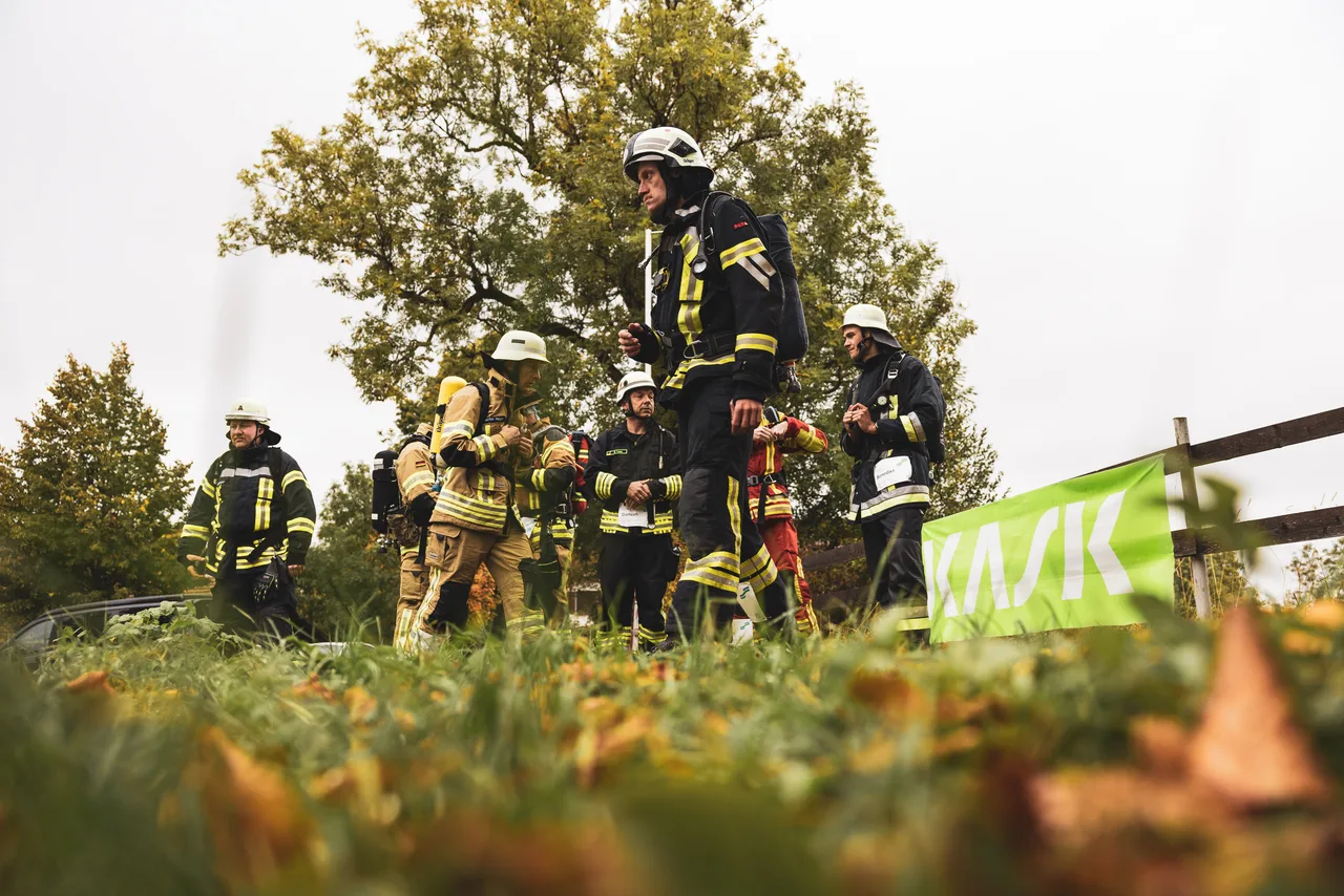 Ein Feuerwehrmann setzt sich vor wartenden Teilnehmern und einem grünen Banner in Bewegung.