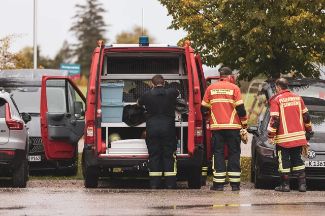 Teilnehmer neben dem geöffneten Heck eines Rettungsfahrzeugs.