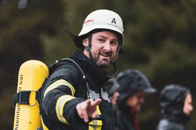 Teilnehmer mit weißem Helm und Bart im Gespräch nach dem Zieleinlauf.