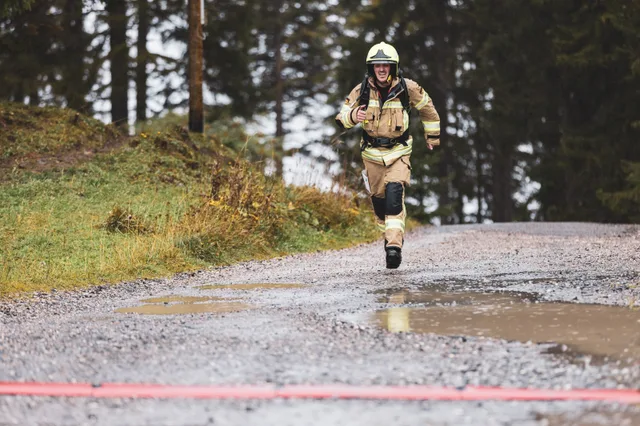 Teilnehmer in beiger Einsatzkleidung läuft auf die Zielmarkierung zu.