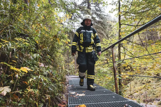 Teilnehmer mit weißem Helm und dunkler Einsatzkleidung steigt die Treppe hinauf.