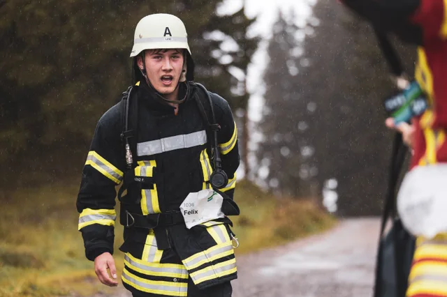 Teilnehmer mit weißem Helm und schwarzer Einsatzkleidung nach dem Zieleinlauf.