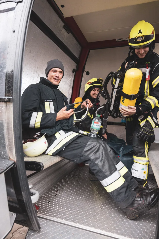Teilnehmer in Einsatzkleidung sitzen in der Gondel der Alpspitzbahn.