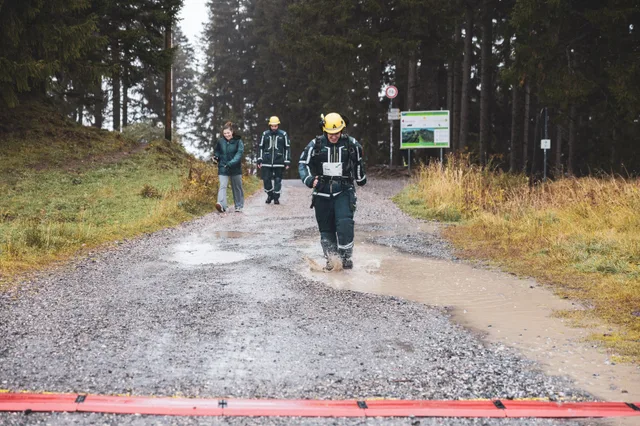 Teilnehmer mit gelbem Helm und dunkler Einsatzkleidung erreicht das Ziel.