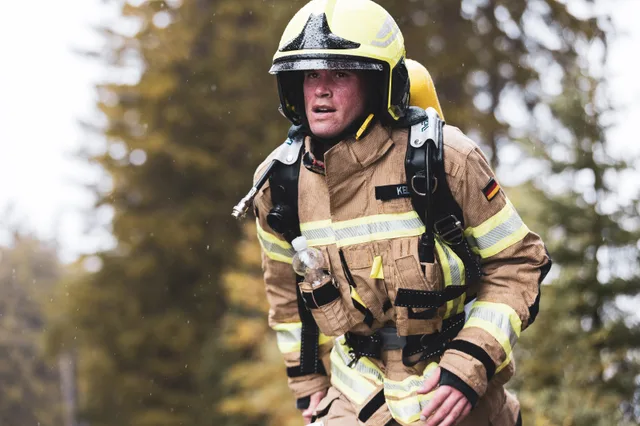Teilnehmer mit gelbem Helm und beiger Einsatzkleidung am Ende des Aufstiegs.