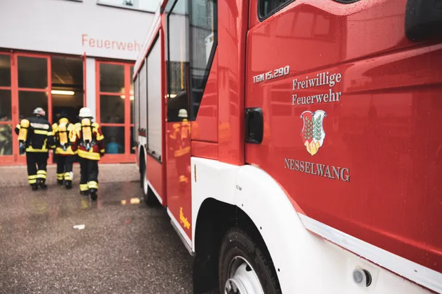 Teilnehmer gehen neben einem Feuerwehrfahrzeug zum Feuerwehrhaus.