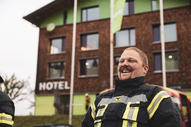 Lachender Teilnehmer vor dem Explorer Hotel.