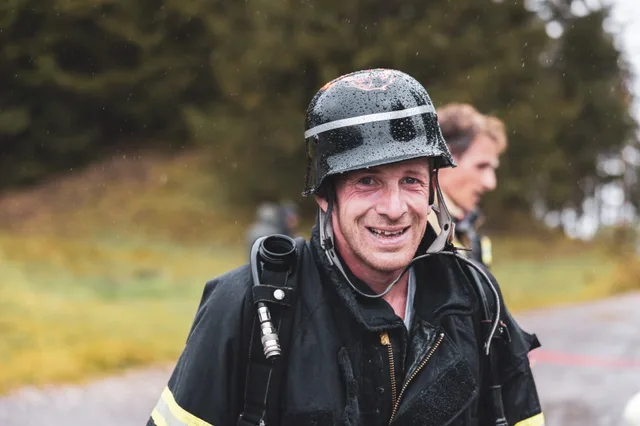 Lachender Teilnehmer mit schwarzem Helm nach dem Zieleinlauf.