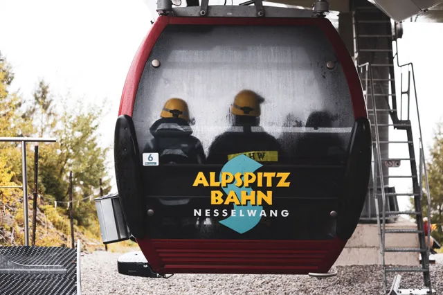 Gondel der Alpspitzbahn mit Teilnehmern verlässt die Station.