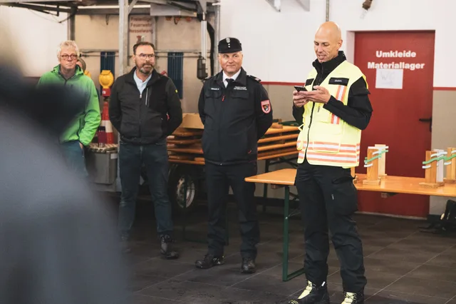 Organisator in Warnweste spricht vor den versammelten Teilnehmern.