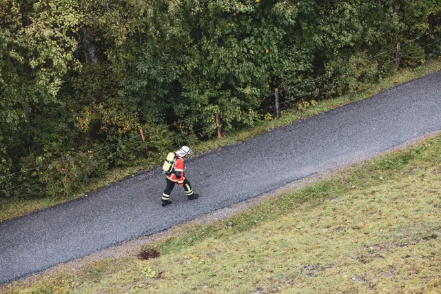 Teilnehmer in roter Einsatzkleidung auf der Bergstraße, von oben gesehen.