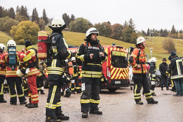 Teilnehmer in dunkler und beiger Einsatzkleidung warten vor dem Start.
