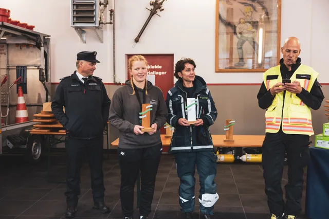 Teilnehmerinnen mit Pokalen neben den Organisatoren.