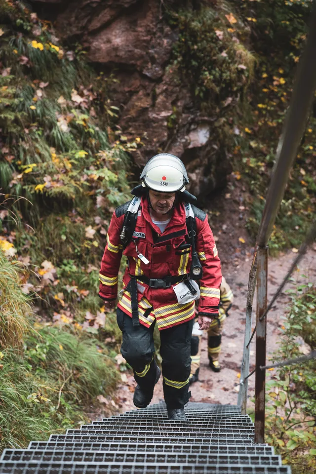 Teilnehmer in roter Einsatzkleidung und weißem Helm auf den Stufen.