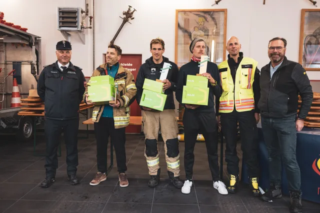Teilnehmer und Organisatoren zeigen Pokale und grüne Preise beim Gruppenbild.