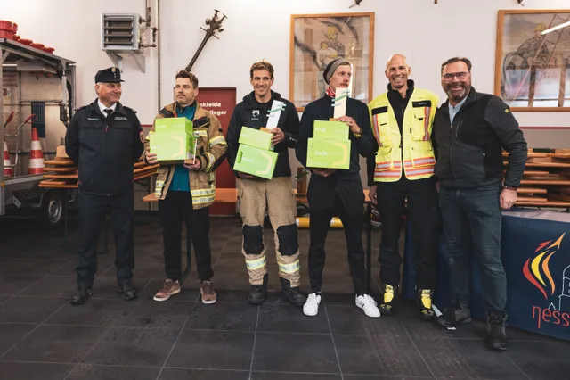 Teilnehmer und Organisatoren zeigen Pokale und grüne Preise beim Gruppenbild.