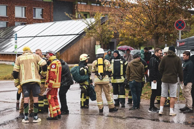 Teilnehmer mit Atemschutzgeräten von hinten im Startbereich.