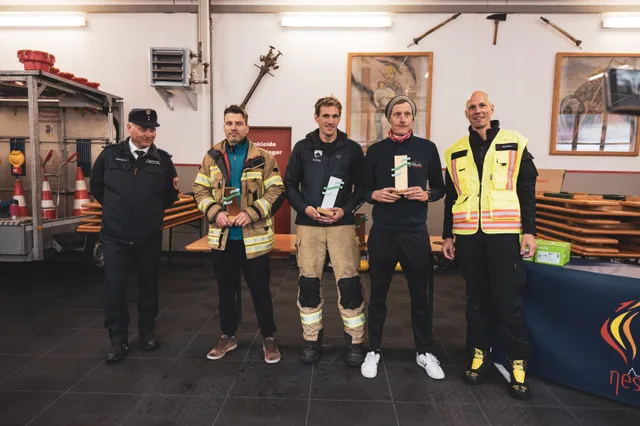 Teilnehmer mit Pokalen beim Gruppenbild im Feuerwehrhaus.