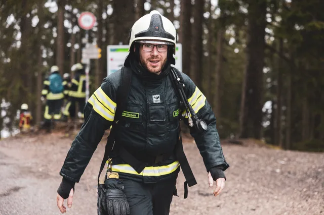 Teilnehmer mit dunklem Helm im regennassen Zielbereich.