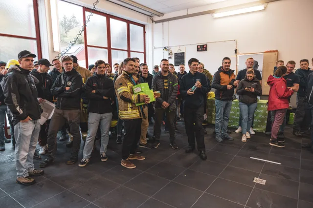 Teilnehmer und Zuschauer applaudieren im Feuerwehrhaus.