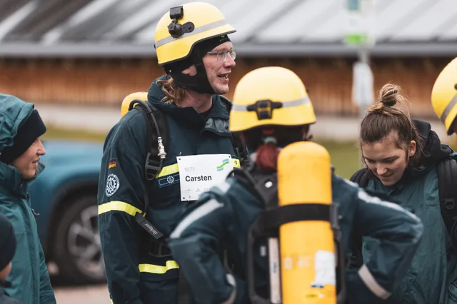 Lachende Gruppe mit gelben Feuerwehrhelmen.