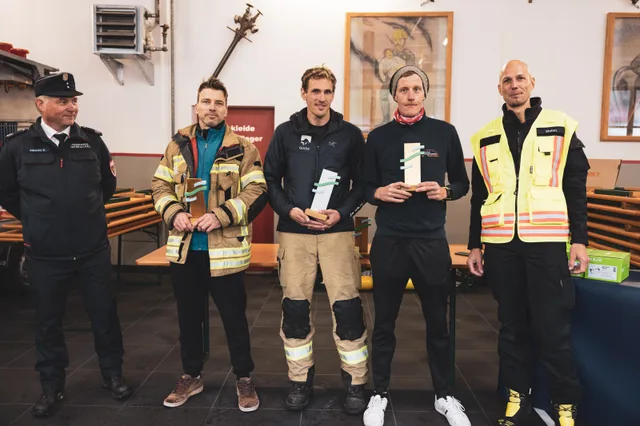 Teilnehmer mit Pokalen beim Gruppenbild im Feuerwehrhaus.