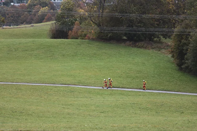 Menschen auf einem Weg am grünen Berghang.