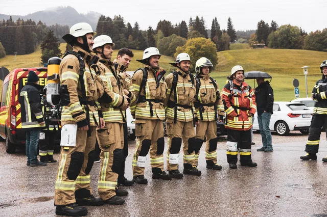 Teilnehmer in dunkler und beiger Einsatzkleidung warten vor dem Start.
