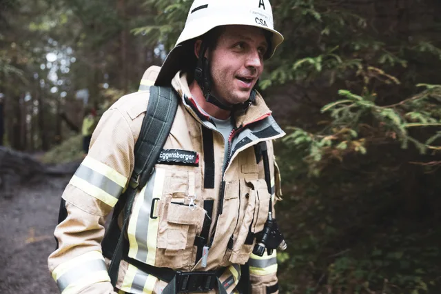 Lächelnder Teilnehmer in beiger Einsatzkleidung mit weißem Helm.