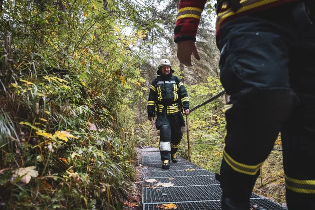 Teilnehmer in schwarzer Einsatzkleidung auf der Treppe hinter einer roten Jacke.